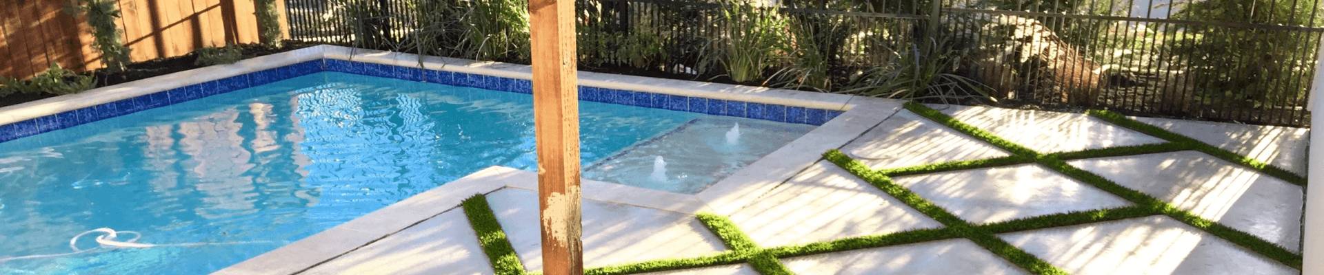 pool with a decking strips in side that use artificial grass.