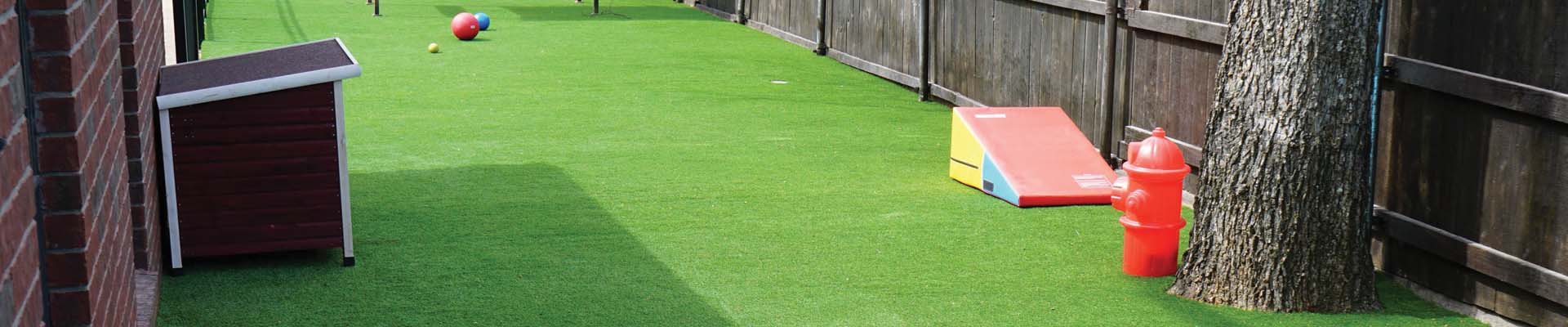 pet playground in backyard, dog house surrounded by artificial grass